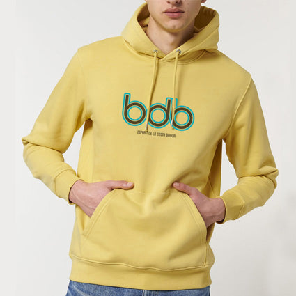 SUDADERA GINESTA de color amarillo mantequilla, con logotipo de BDB en la parte delantera en dos colores y bajo impreso ESPERIT DE LA COSTA BRAVA.